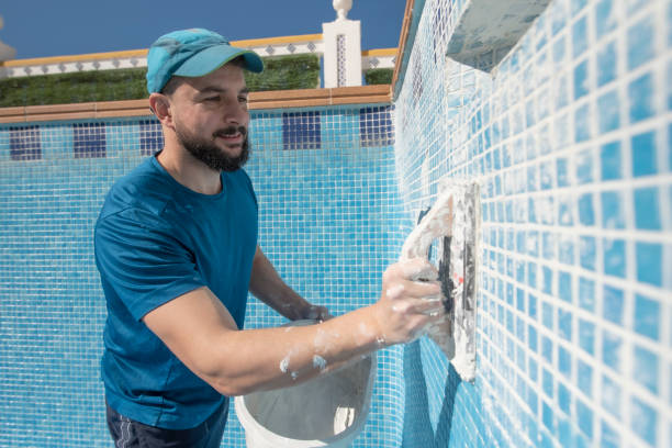 Man cleaning pool grout with a scrub brush and a bucket, illustrating DIY cleaning methods with home supplies.